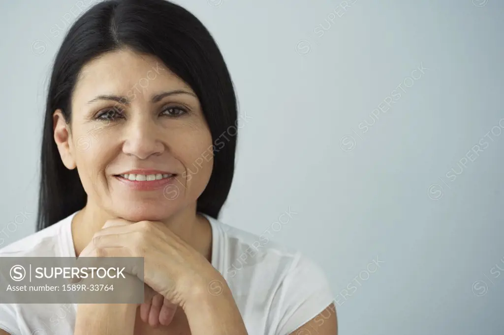 Hispanic woman resting chin on hands