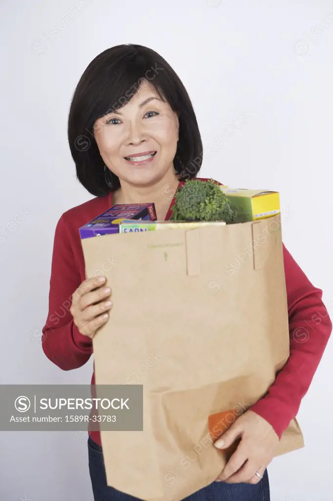 Senior Asian woman carrying grocery bag