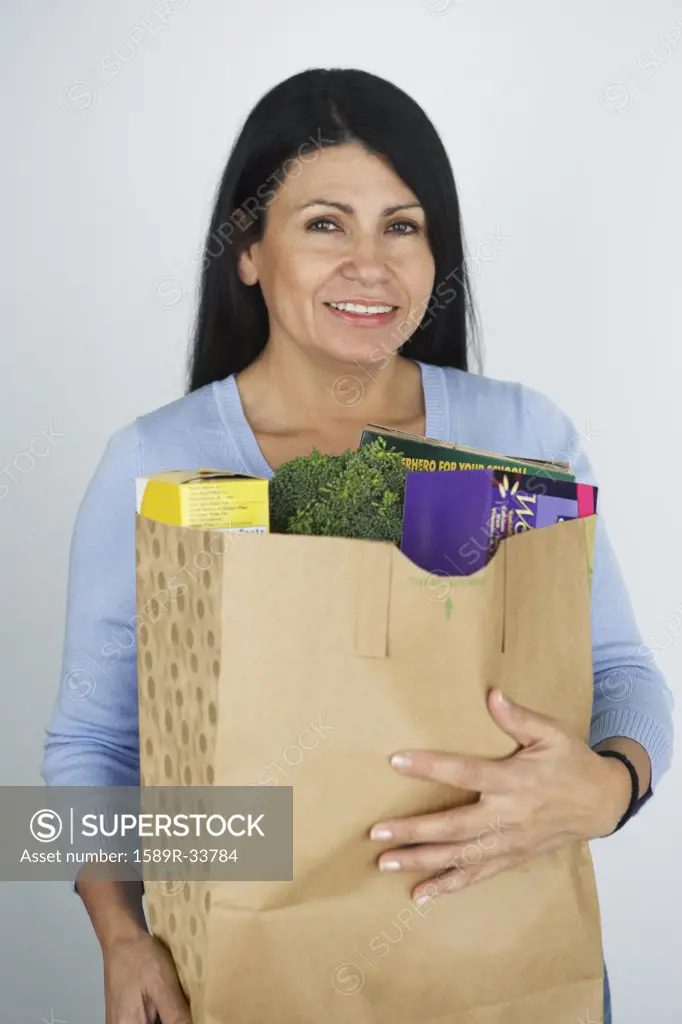 Hispanic woman carrying grocery bag