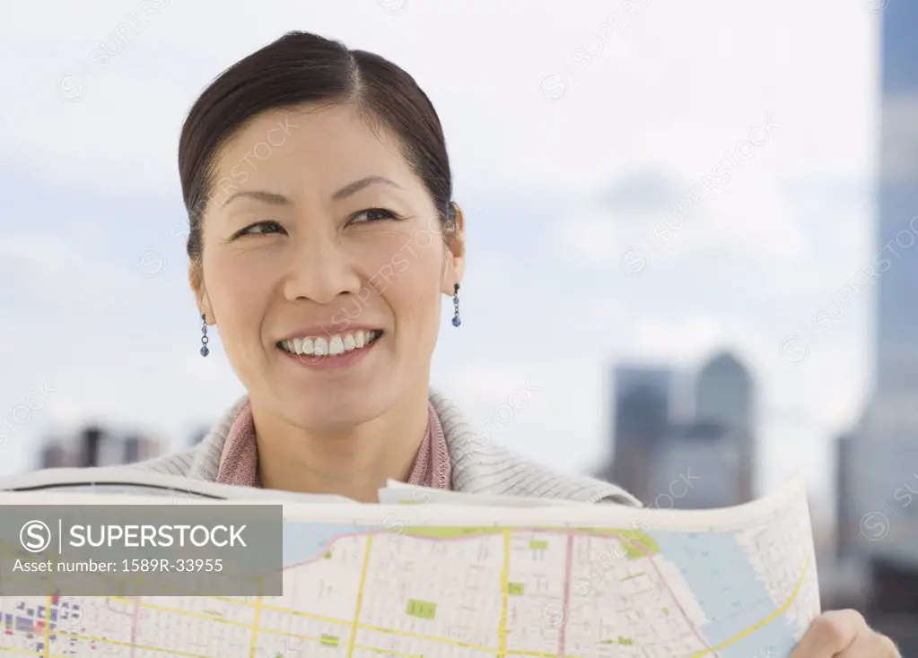 Middle-aged Asian woman holding map 