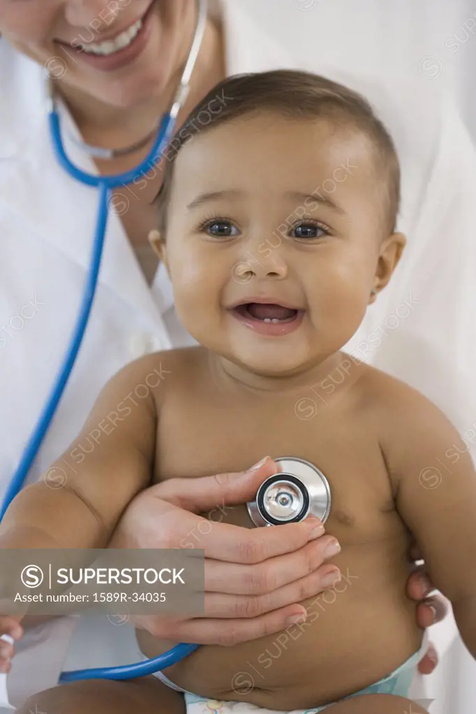 Hispanic baby being examined by doctor