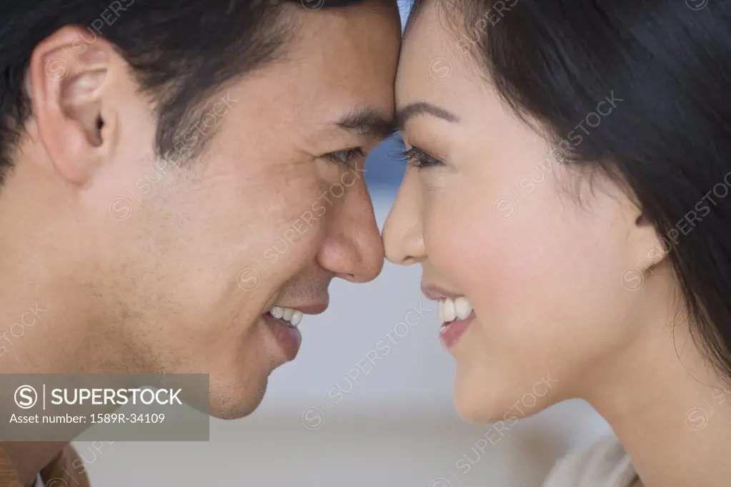 Close up of Asian couple touching foreheads