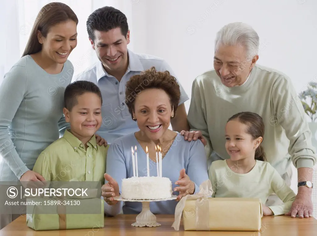 Senior Hispanic woman celebrating birthday with family
