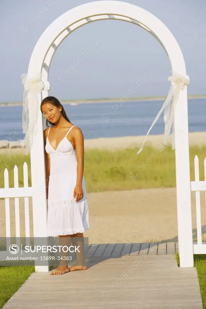 Asian woman in archway at beach