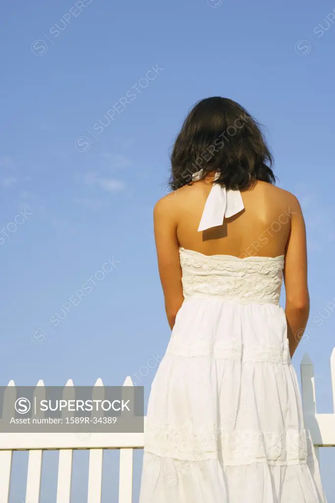 Rear view of woman next to fence