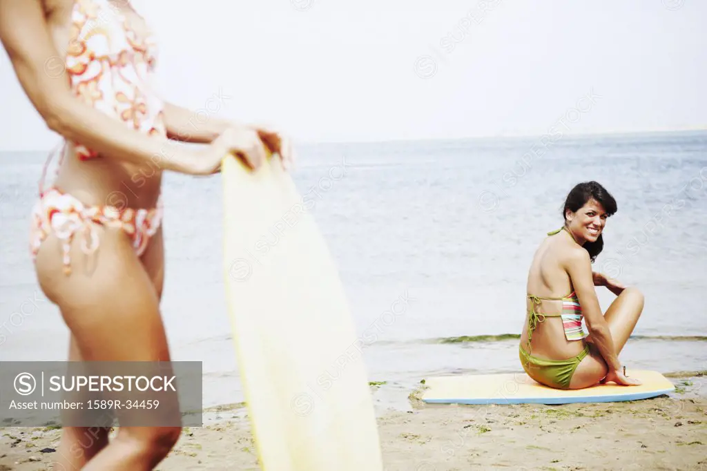 Young women with boogie boards at beach