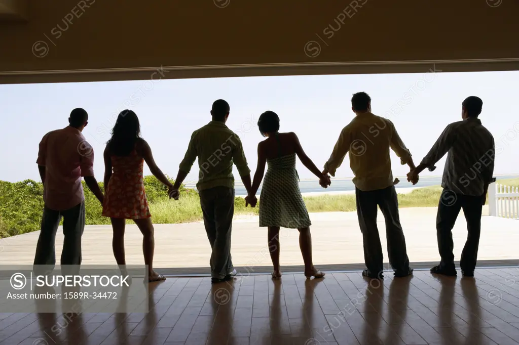 Silhouette of friends holding hands at beach resort