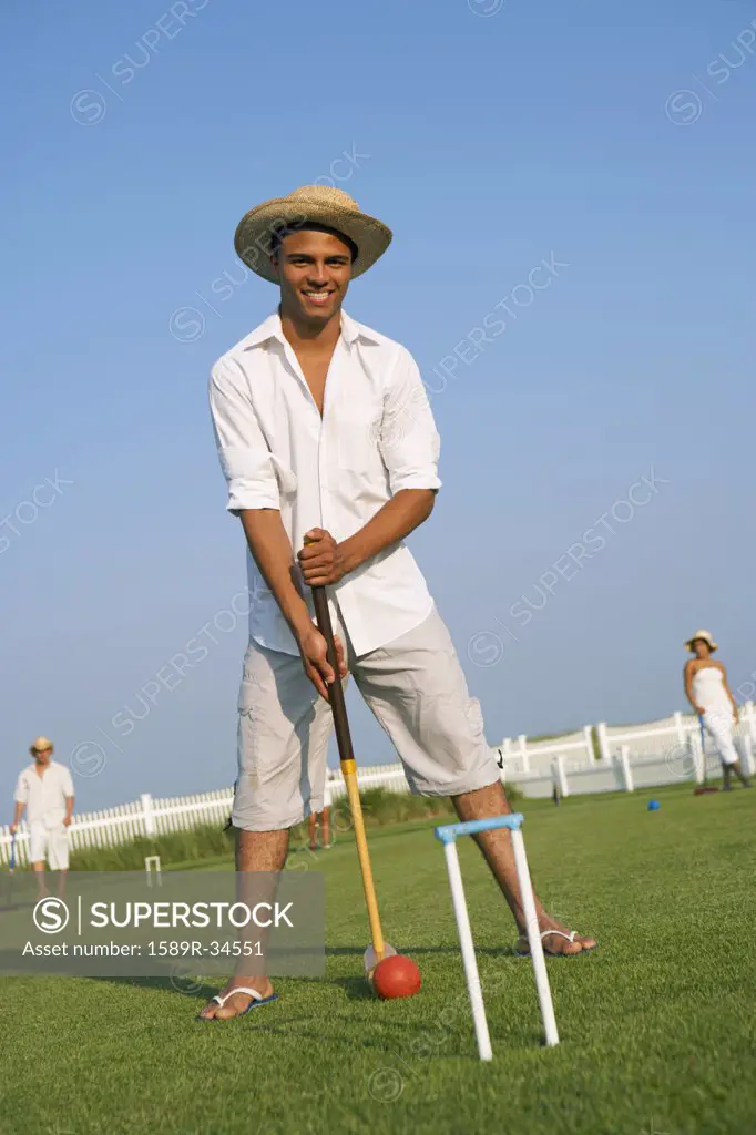Hispanic man playing croquet