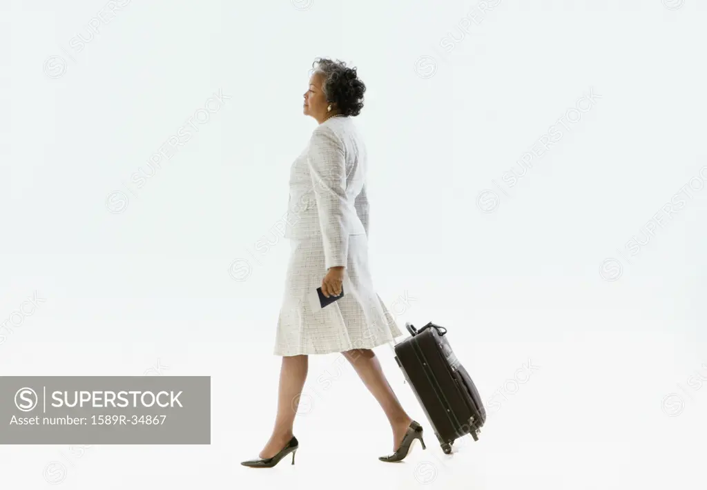 African businesswoman pulling suitcase
