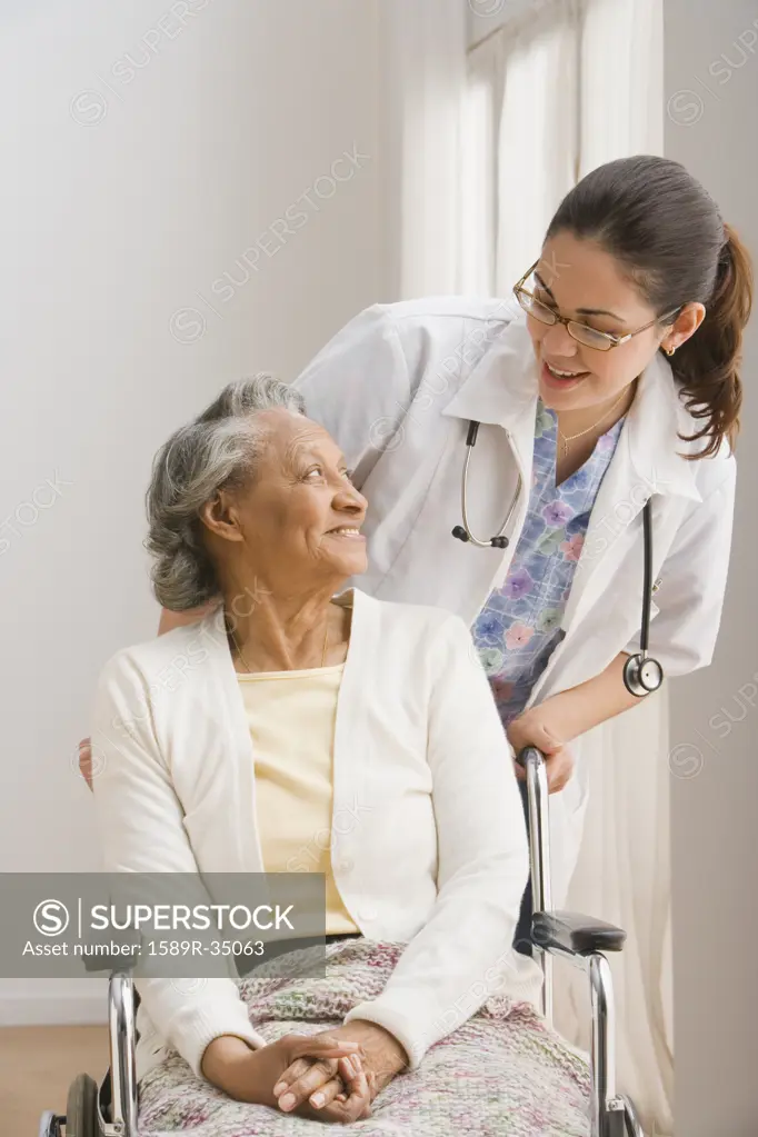 Senior African woman in wheelchair talking to female doctor