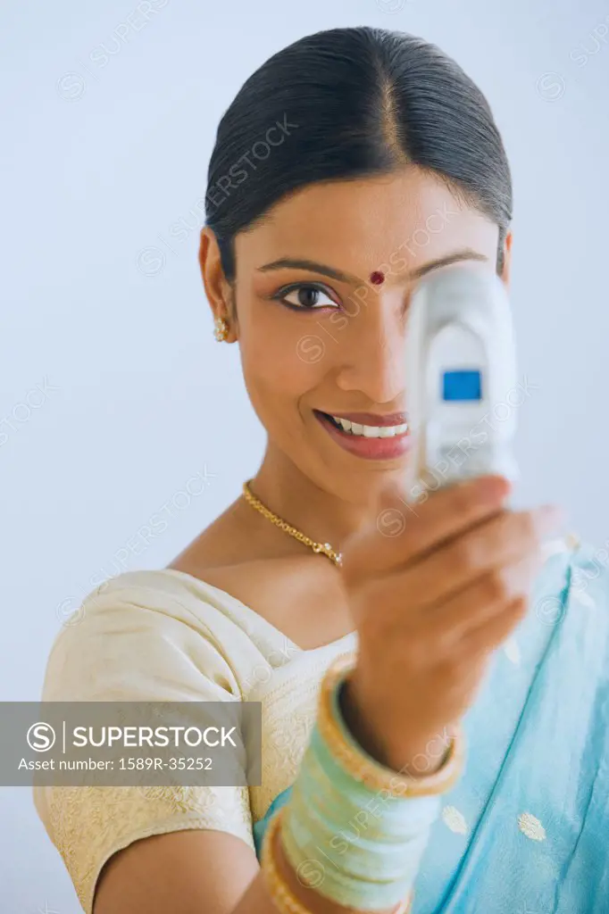 Indian woman in traditional clothing using cell phone camera