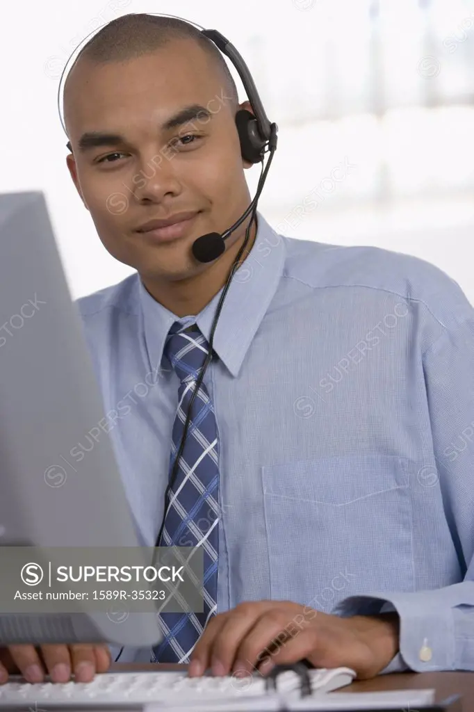 Asian businessman wearing headset at desk
