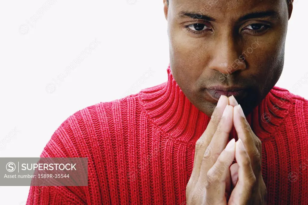 African man with hands together in front of chin