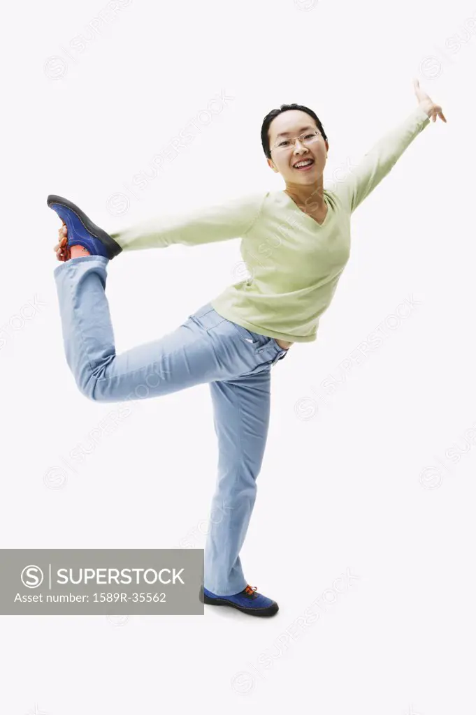 Portrait of Asian woman holding leg up