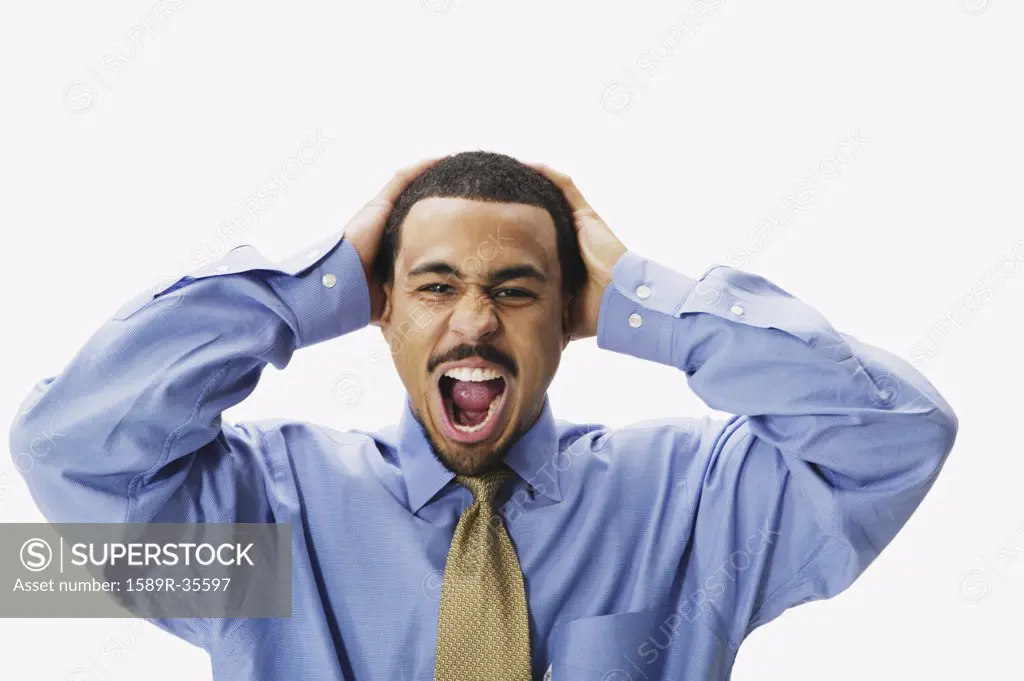 African businessman yelling with hands on head