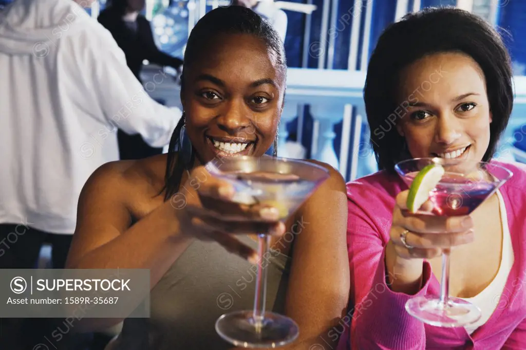 Two African women toasting with cocktails
