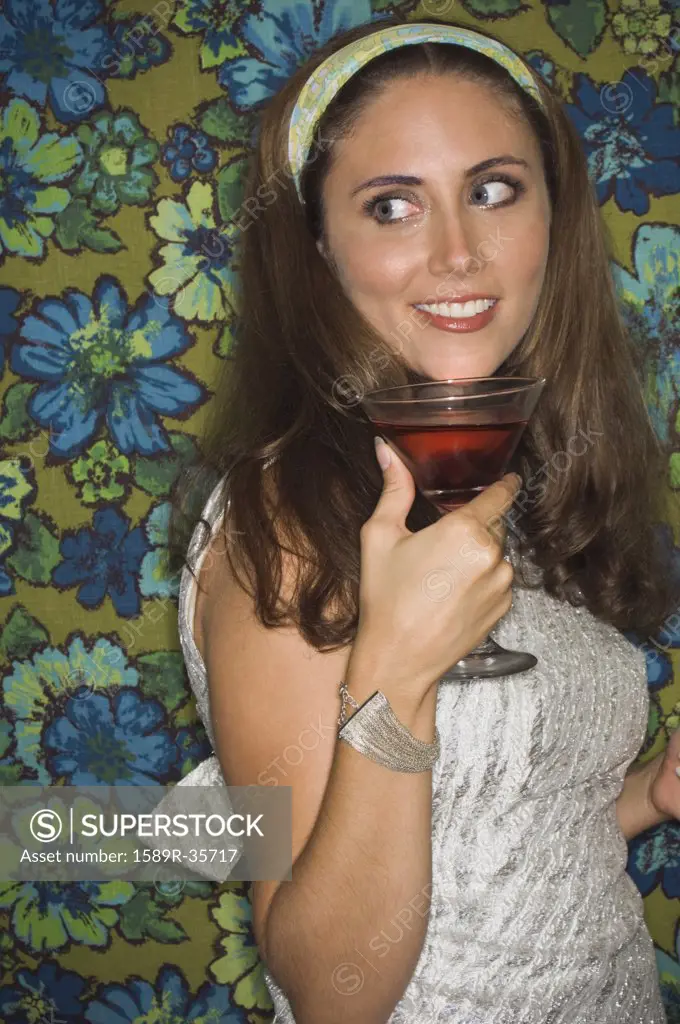 Young woman in retro outfit holding cocktail