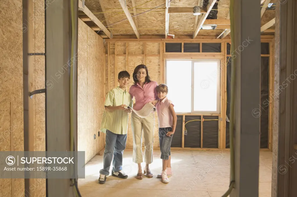 Family with blueprints on construction site