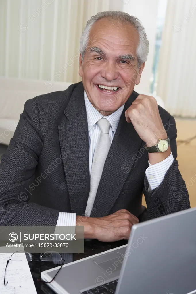 Senior businessman with laptop at desk