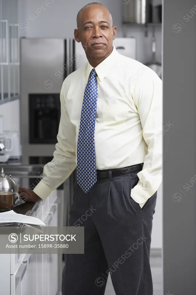 Senior African businessman standing in kitchen