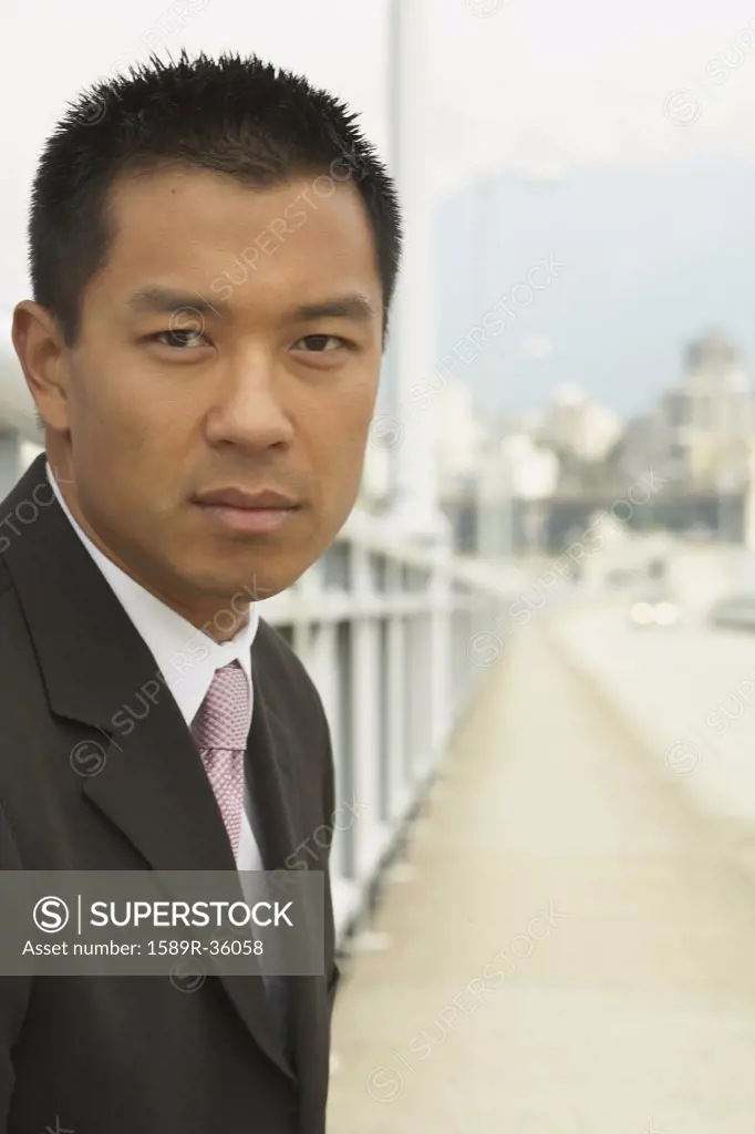 Portrait of Asian businessman on urban bridge
