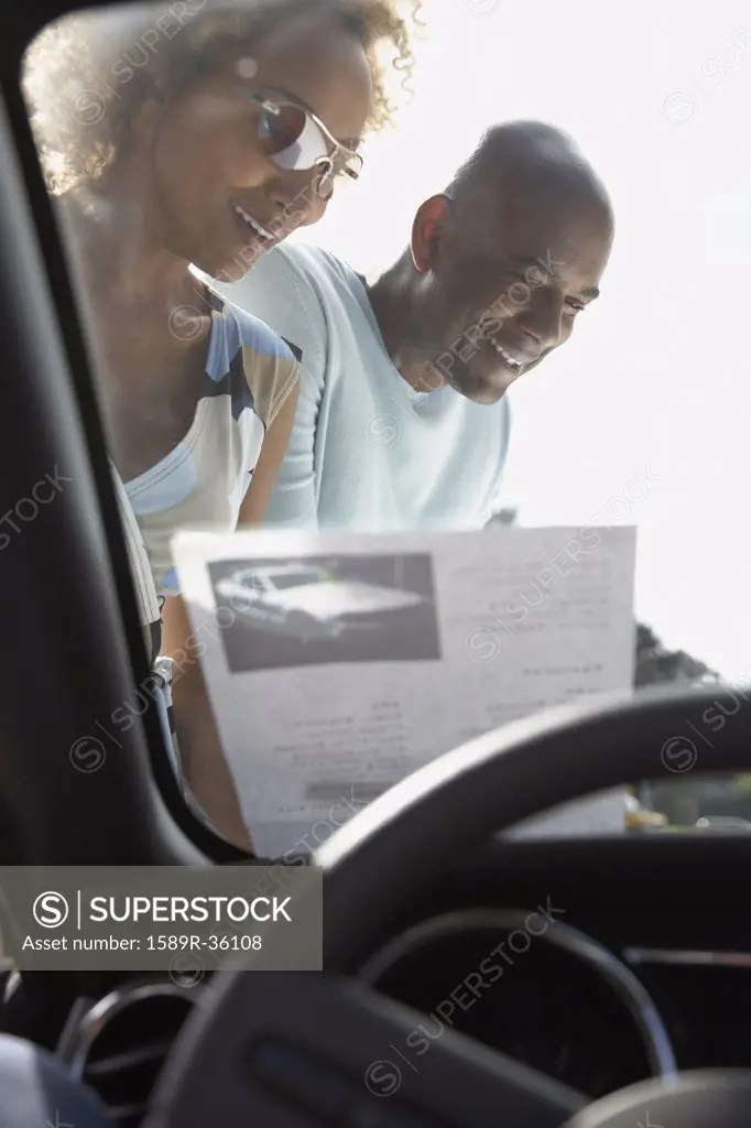 Portrait of African couple through car windshield