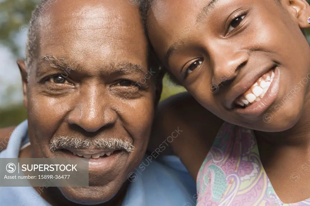 Close up of African grandfather and granddaughter smiling