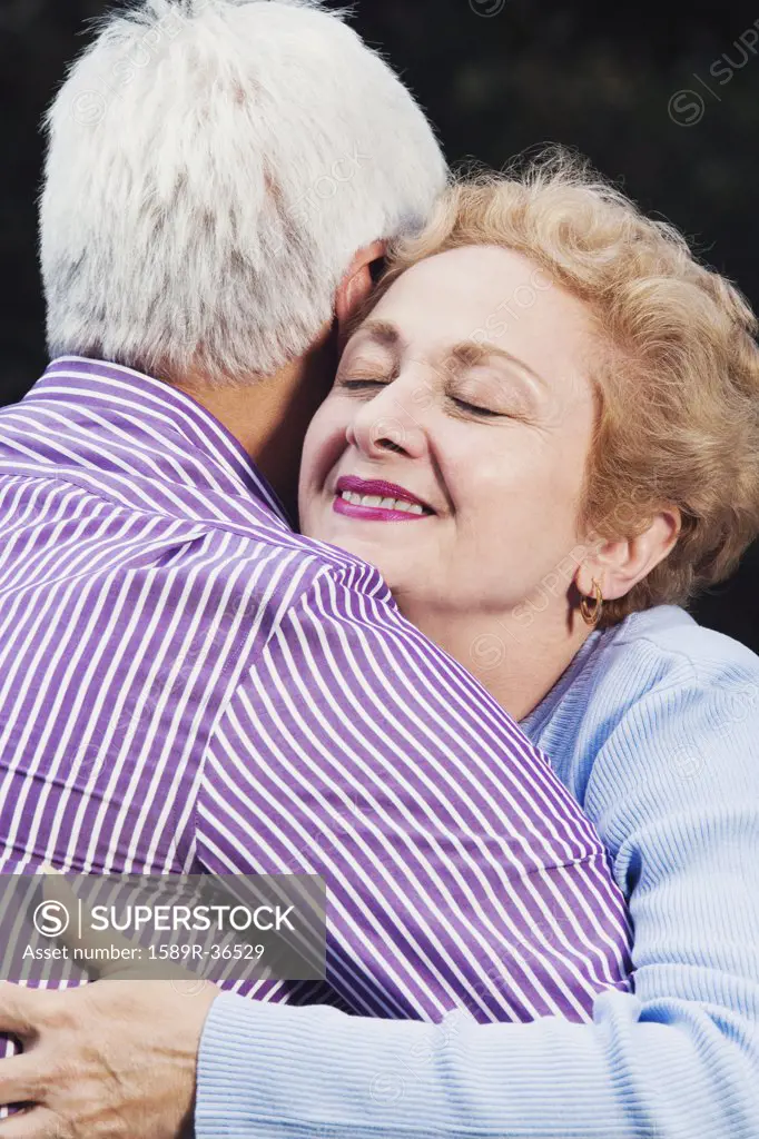 Close up of senior Hispanic couple hugging
