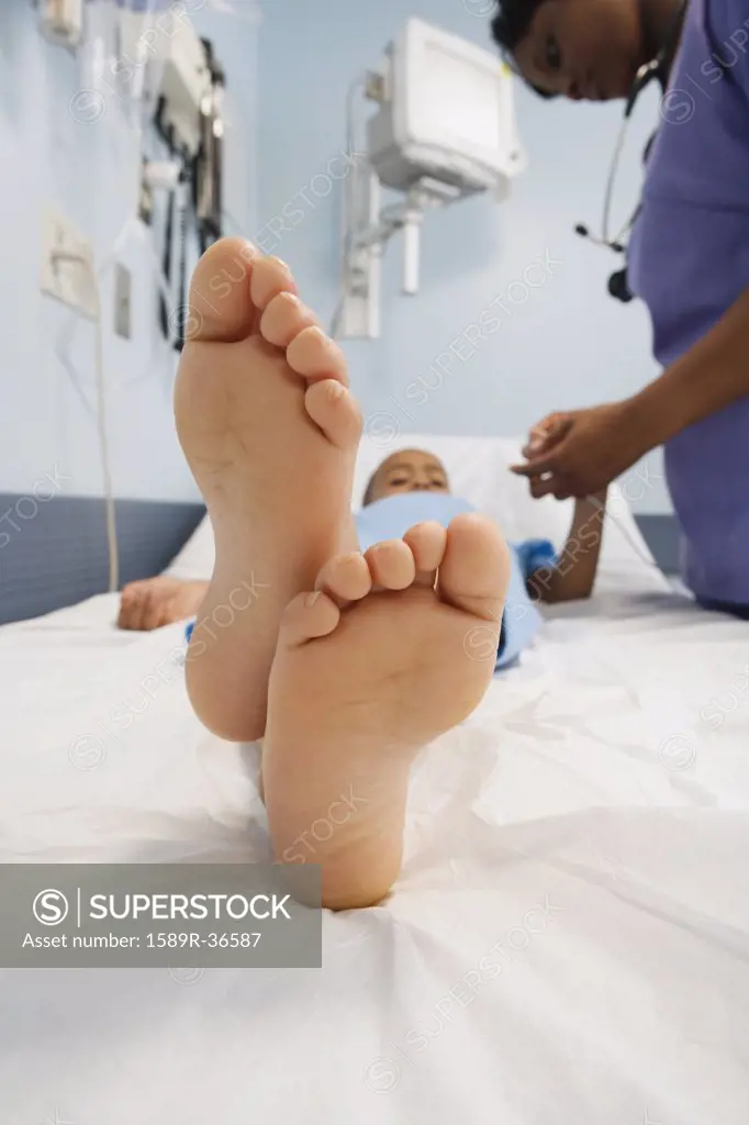 Close up of African boys bare feet in hospital bed