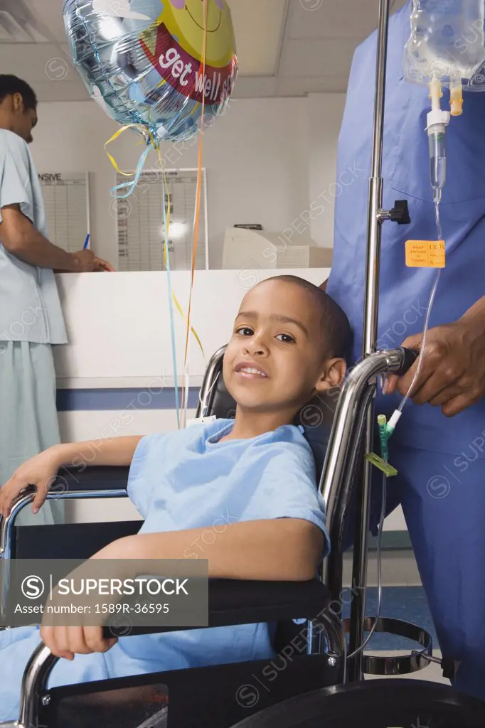 African boy being pushed in wheelchair in hospital