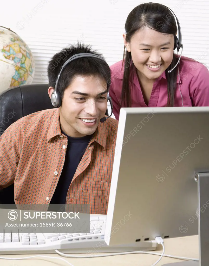 Two young businesspeople looking at computer
