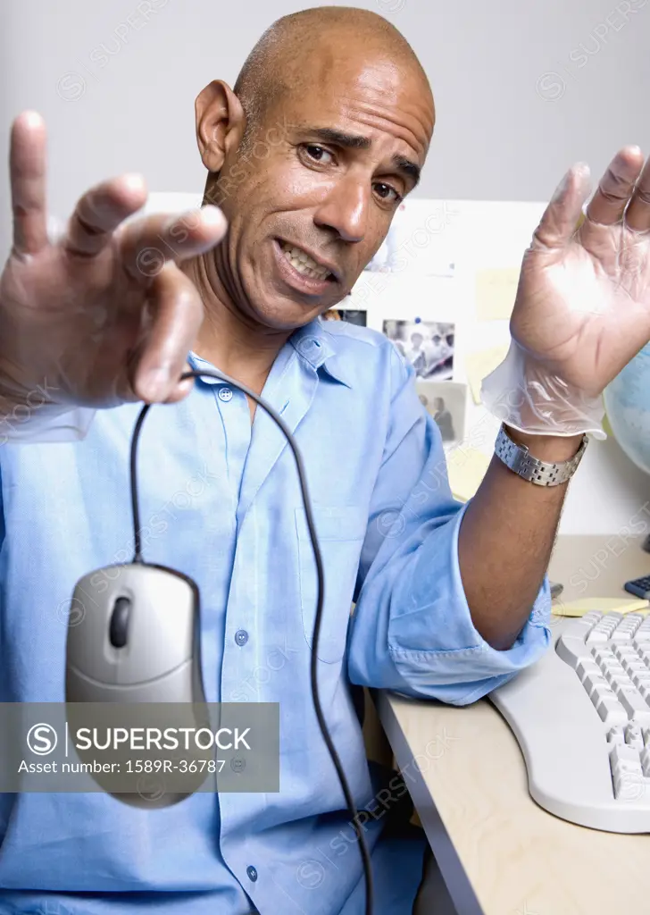 Middle-aged African businessman holding computer mouse