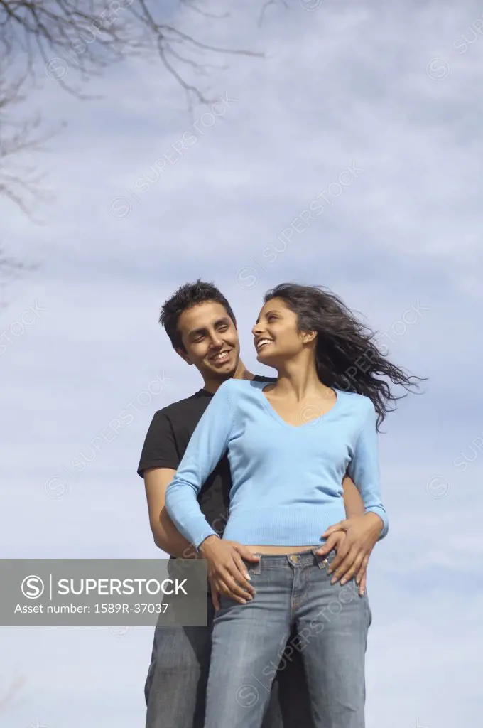 Low angle view of couple hugging
