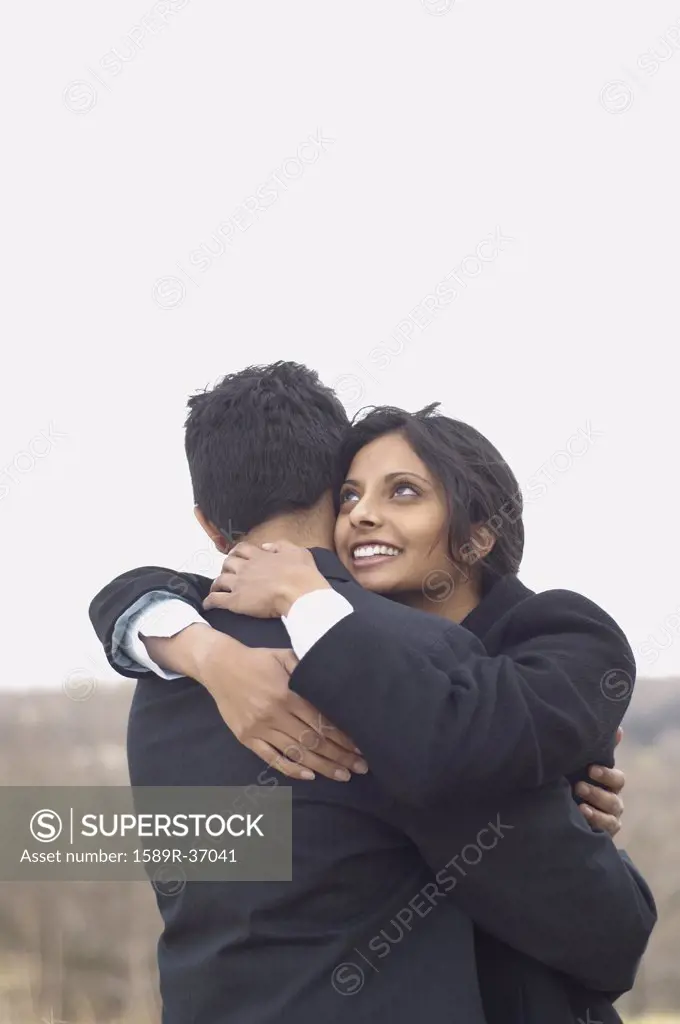 Portrait of couple hugging outdoors