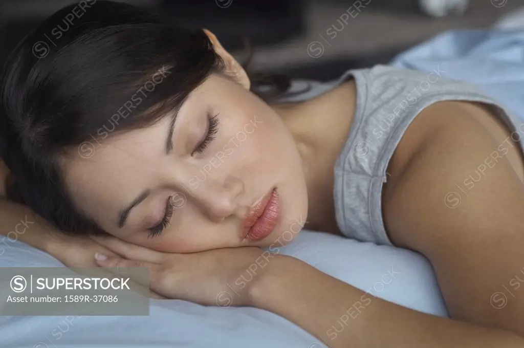 Close up of Hispanic woman sleeping in bed