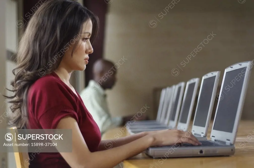 Hispanic woman using laptop at computer lab