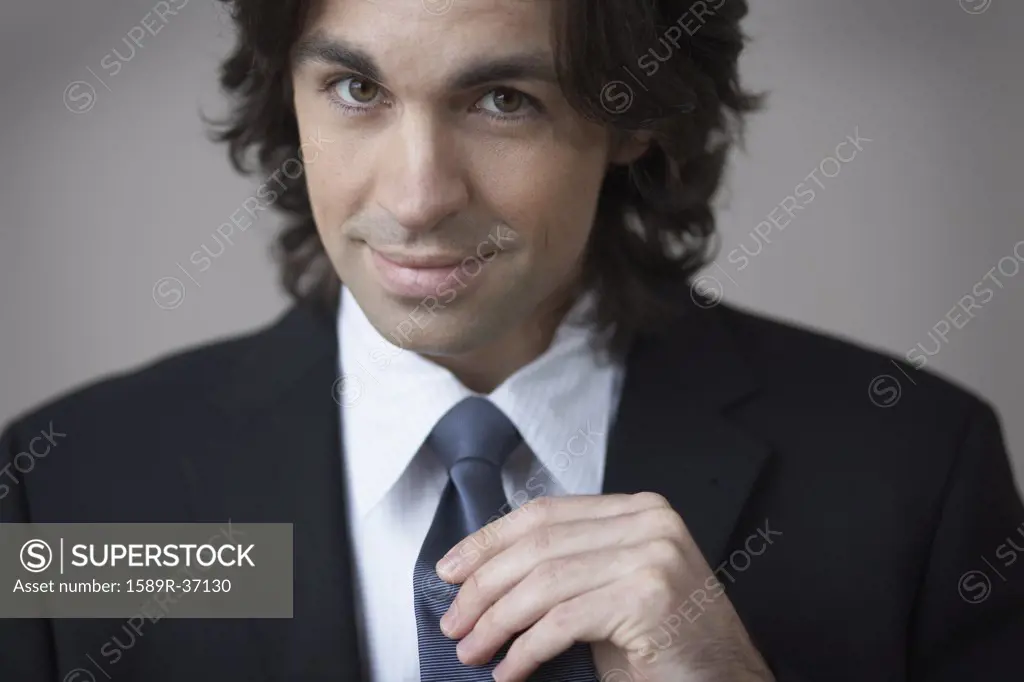 Portrait of businessman holding necktie