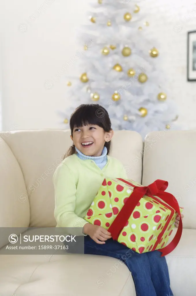 Hispanic girl holding Christmas gift
