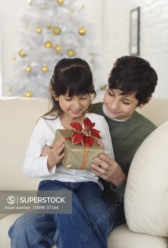 Hispanic brother and sister holding Christmas gift