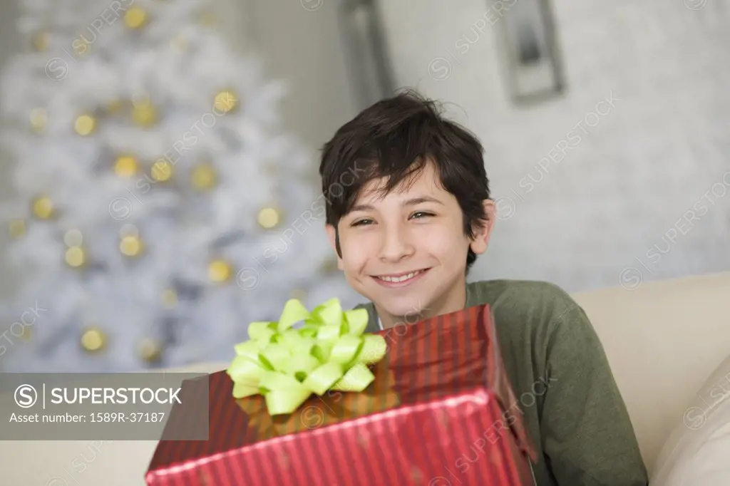 Hispanic boy holding Christmas gift