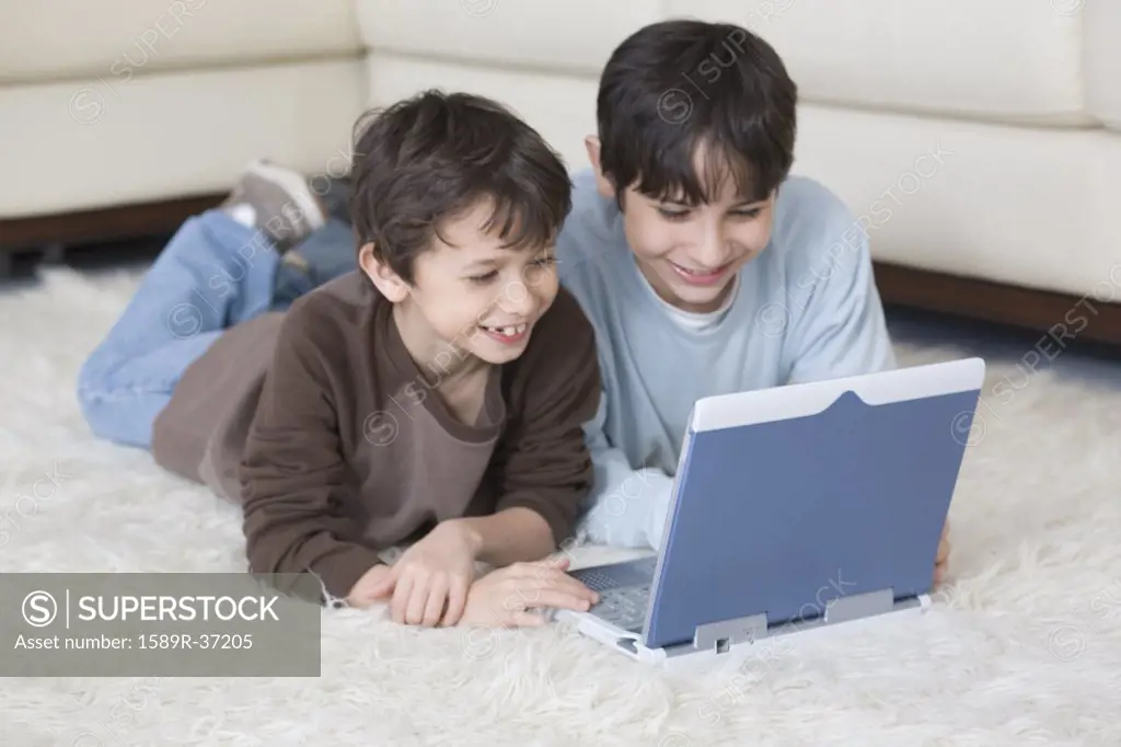 Hispanic brothers looking at laptop