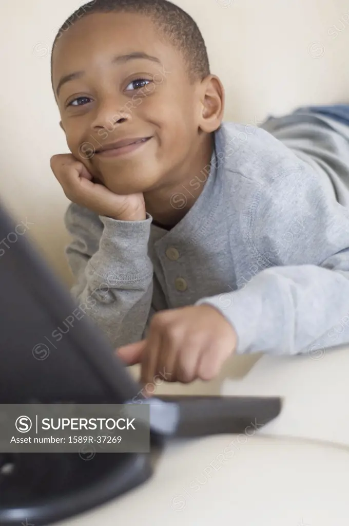 African boy typing on laptop