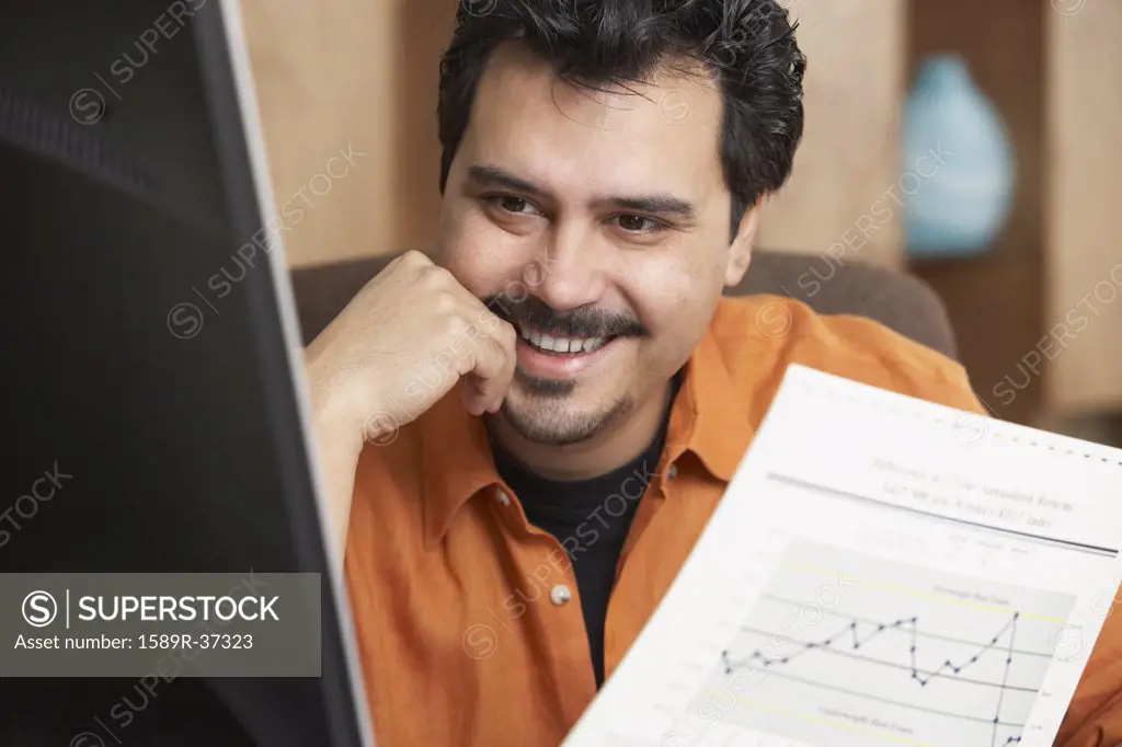 Hispanic businessman holding graph