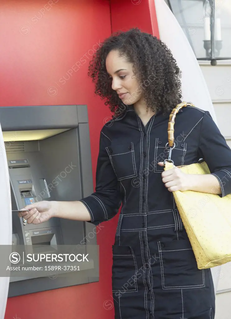 Hispanic woman using ATM