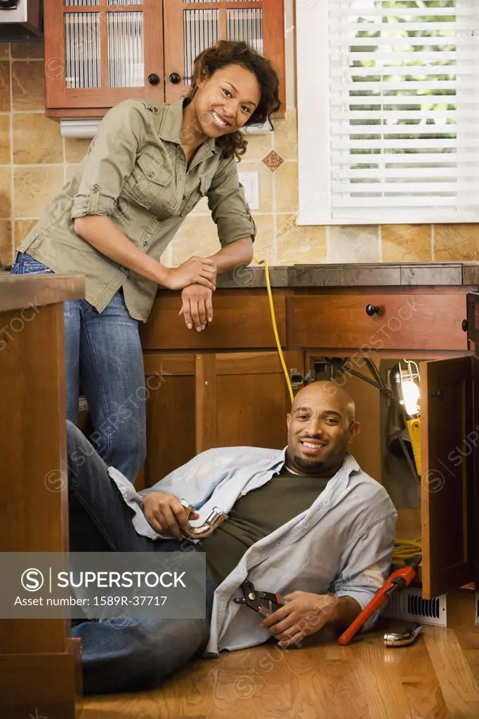 African couple installing kitchen sink
