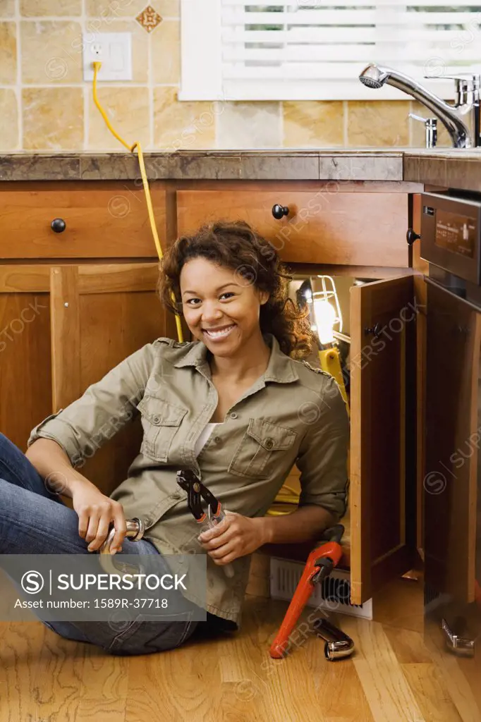 African woman installing kitchen sink