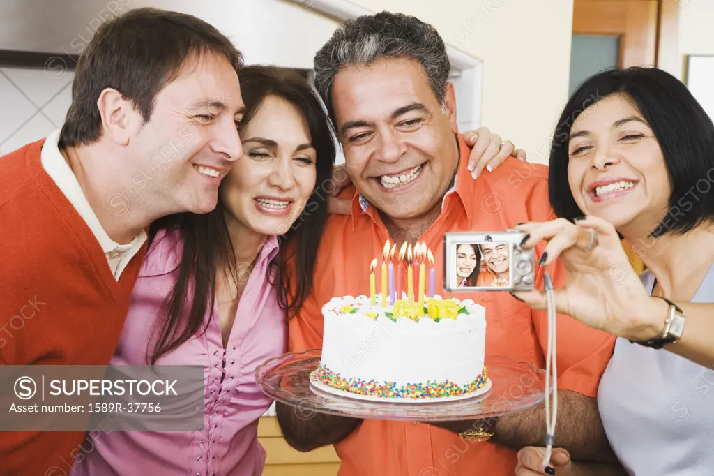 Middle-aged man having photograph taken on birthday