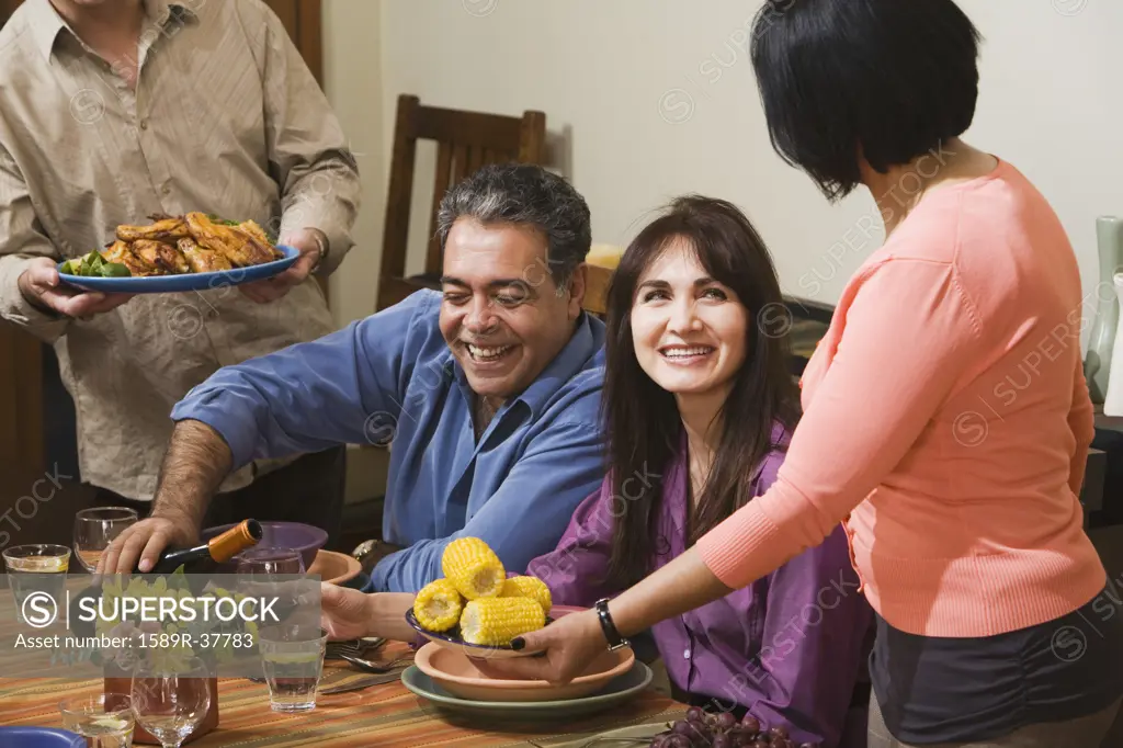Middle-aged Hispanic couple at dinner party