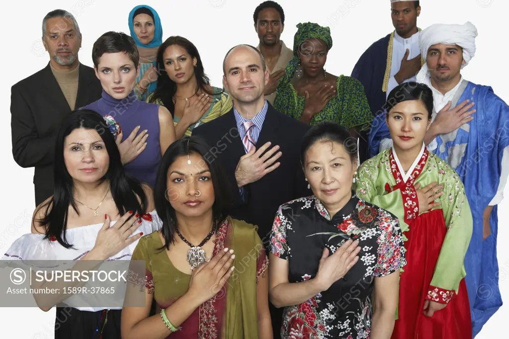 Multi-ethnic people in traditional dress holding hand on heart