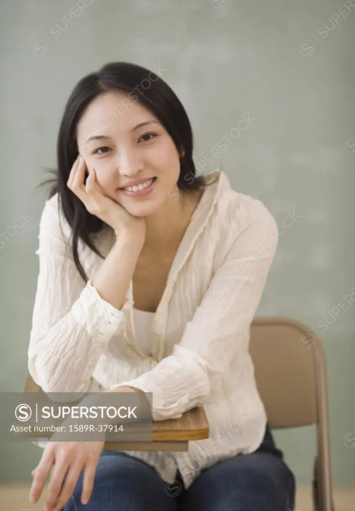Asian woman sitting at school desk